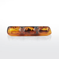 Nashi Home Swirl Resin Colored 3 Section Tray, featuring translucent amber and brown marbled swirls, is displayed on a white reflective surface.
