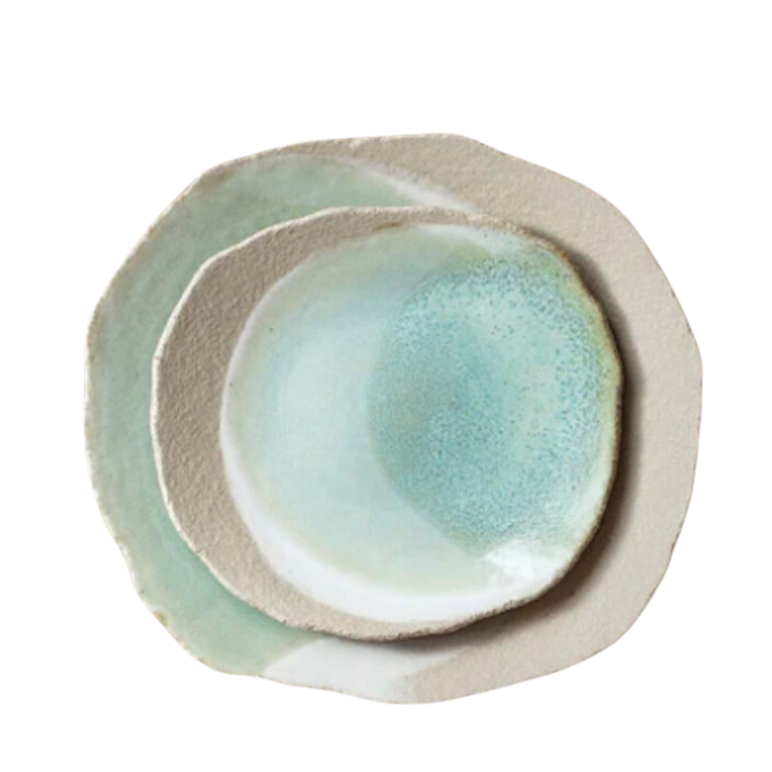Two irregularly shaped handmade Jars Wabi Dinnerware Vert plates—one smaller, nested in a larger—feature textured off-white rims and glossy blue-green centers with organic edges; ideal as a Wabi Sabi dessert plate set.