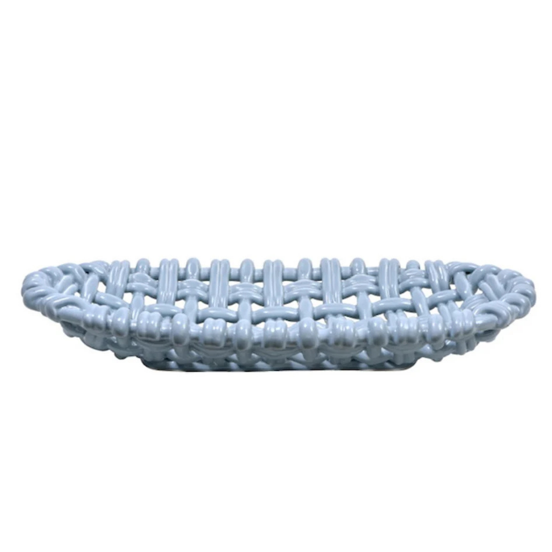 The Woven Basket Oval by Skyros is a light blue ceramic piece with an open, woven design, handcrafted by artisans in Condeixa, Portugal. Shown from the side against a plain white background.
