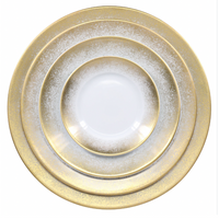 The Royal Limoges Yellow Fire Dinnerware set features three round Limoges porcelain plates with white centers and sparkling yellow gold rims, stacked from largest to smallest against a white background.