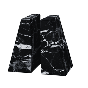 The Zeus Marble Bookend Set by Designs by Marble Crafter features two handcrafted black marble bookends with striking white veining, each shaped like a trapezoidal prism. Displayed side by side on a white background, these elegant accents elevate the decor of any room.