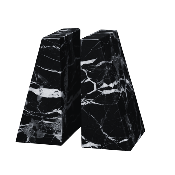 The Zeus Marble Bookend Set by Designs by Marble Crafter features two handcrafted black marble bookends with striking white veining, each shaped like a trapezoidal prism. Displayed side by side on a white background, these elegant accents elevate the decor of any room.