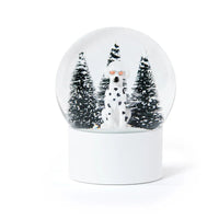 A Zodax Dalmatian Snow Globe featuring a dog wearing sunglasses in front of three snow-covered pine trees.