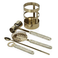 The Zodax Armor Gold 5 Piece Bar Set includes a gold and white cocktail set with a cylindrical holder, jigger, strainer, mixing spoon, and bottle opener—all featuring elegant gold metal and white marbled handles.