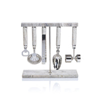 The Zodax Grey Marble Bar Tool 5 Piece Set features bartending essentials—bottle opener, strainer, tongs, ice scoop, and jigger—all with marble handles on a matching stand.