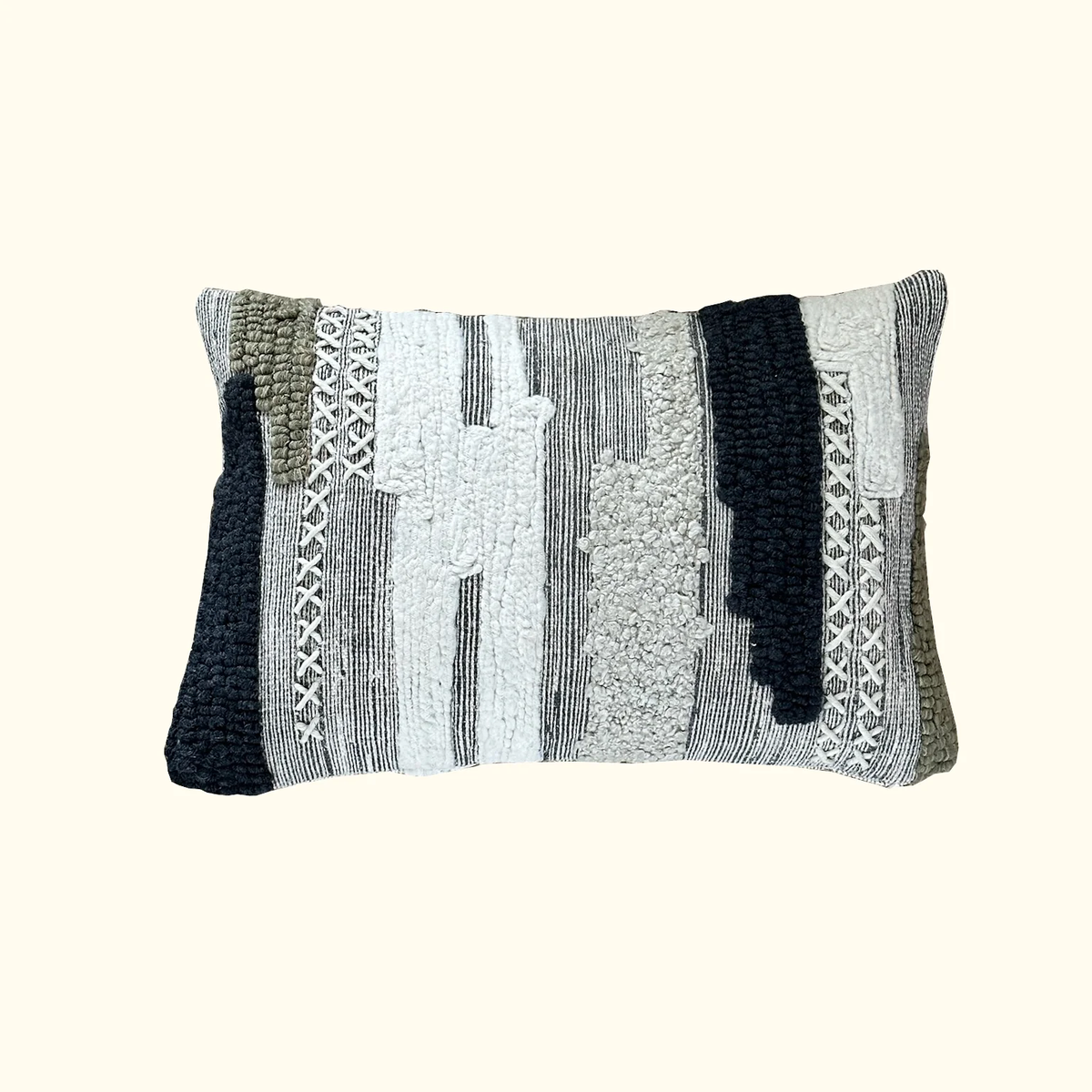 The Terrain Pillow 13 x 20 by Threads Soft Goods is a rectangular luxury pillow featuring a textured, abstract pattern in black, white, olive, and gray tones. Raised, woven, and stitched elements add dimensional interest to its modern design set against a light background.