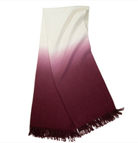 The Johanna Howard Dip Dye Throw features an elegant ombré fade from off-white to deep burgundy, finished with fringe along one edge.