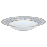 A white porcelain soup plate with a wide rim, adorned with an elegant light blue and gold pattern inspired by Philippe Deshoulieres' Arcades Gold Dinnerware.