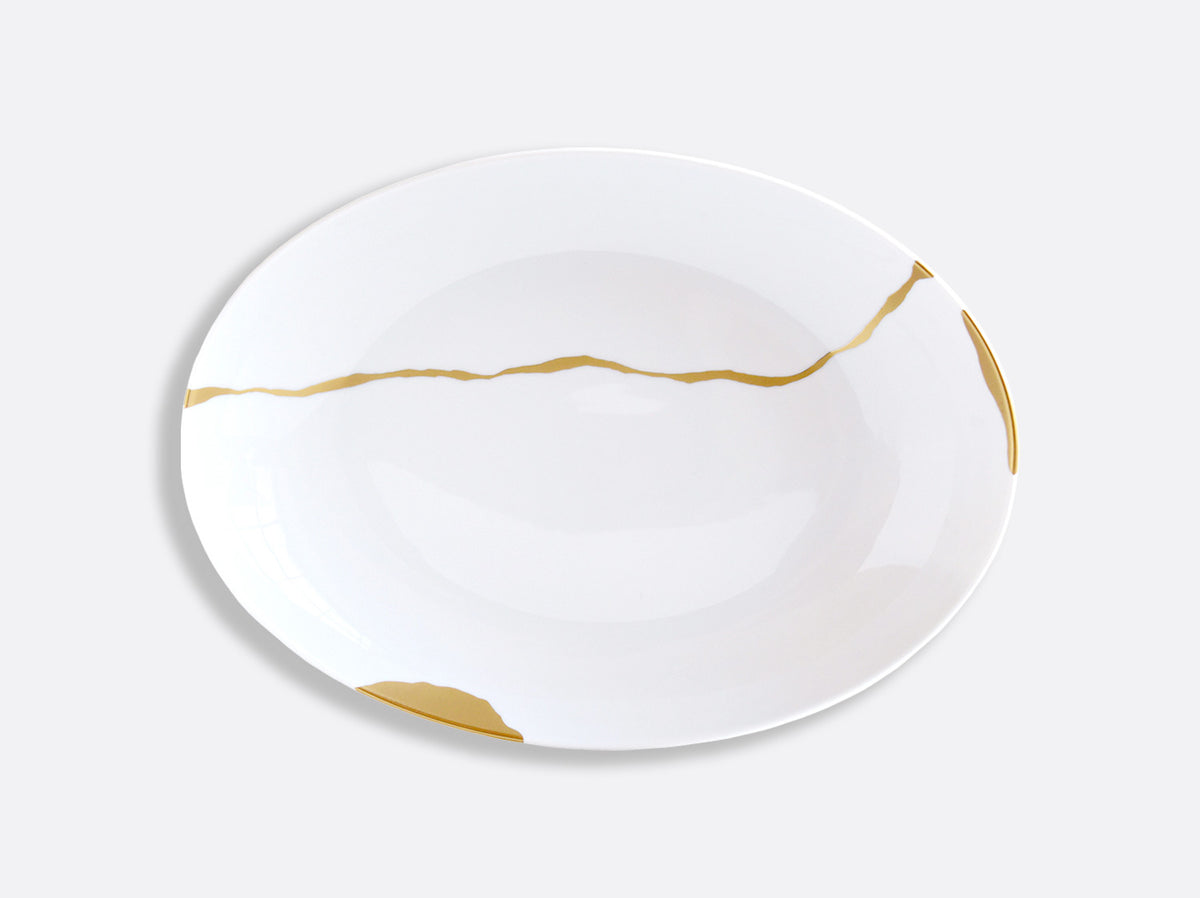The Bernardaud Kintsugi Dinnerware features a white Limoges porcelain plate adorned with gold crack-like lines inspired by Japanese kintsugi, displayed on a plain light gray background.