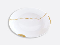The Bernardaud Kintsugi Dinnerware features a white Limoges porcelain plate adorned with gold crack-like lines inspired by Japanese kintsugi, displayed on a plain light gray background.