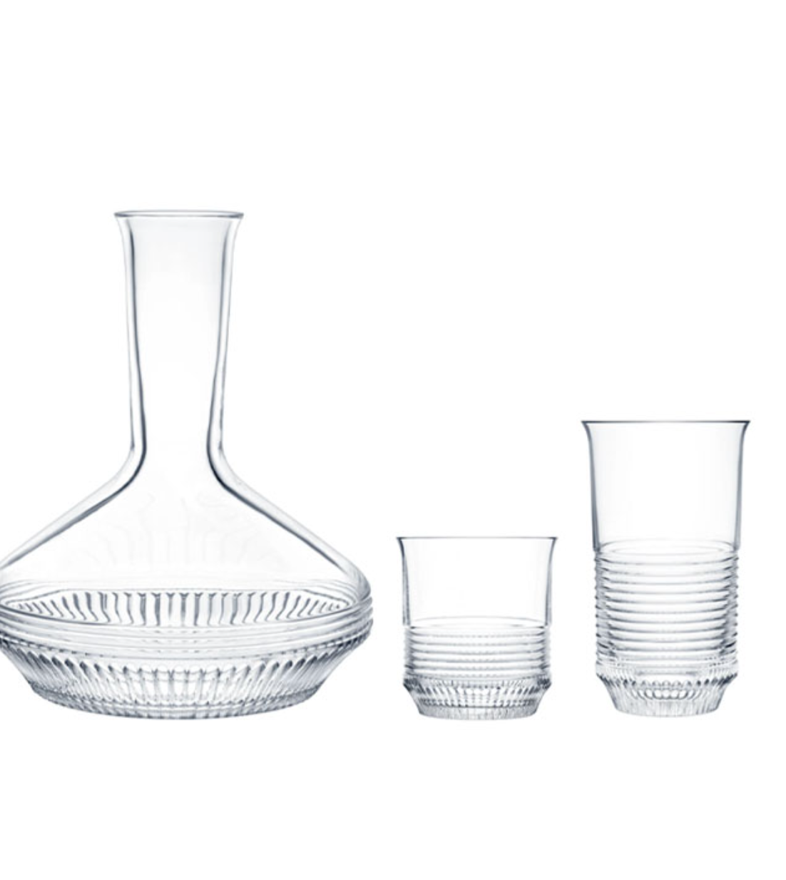 The Cadence Barware by Saint-Louis/Hermes features a clear glass decanter with ribbed detailing, accompanied by two hand-blown crystal tumblers with elegant ribbed bases.