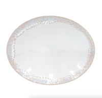 A round, white Taormina Dinnerware plate by Casafina, crafted from fine stoneware with a textured, uneven beige and light brown rim, displayed against a plain white background.