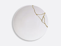The Bernardaud Kintsugi Dinnerware plate is white with gold crack-inspired lines on one side, evoking the Japanese kintsugi technique, set against a plain light background.
