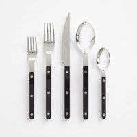 The Sabre Bistrot Solid Flatware 5 Piece Setting - Shiny features two forks, one knife, one tablespoon, and one teaspoon with black handles, arranged side by side on a white background.
