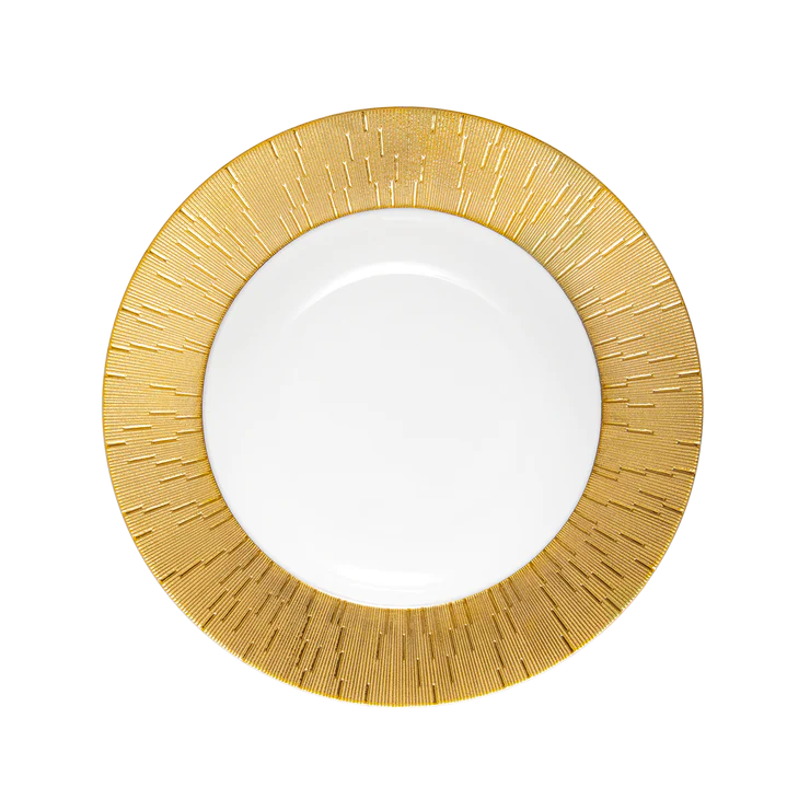 A round white plate from Haviland’s Infini Prestige Gold Dinnerware collection features a wide, textured gold rim with vertical lines radiating outward, crafted in Limoges porcelain and shown against a light background.