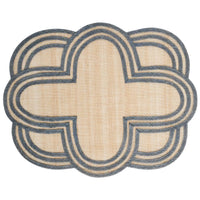The Juliska Scallop Stripe Placemat features a beige center with an intricate blue border in an overlapping, scalloped quatrefoil pattern for a symmetrical, decorative look.