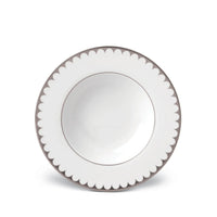 A white ceramic bowl with a scalloped gray-edged rim, viewed from above on a white background, reflects the refined elegance of L’Objet’s Aegean Filet Platinum Dinnerware.