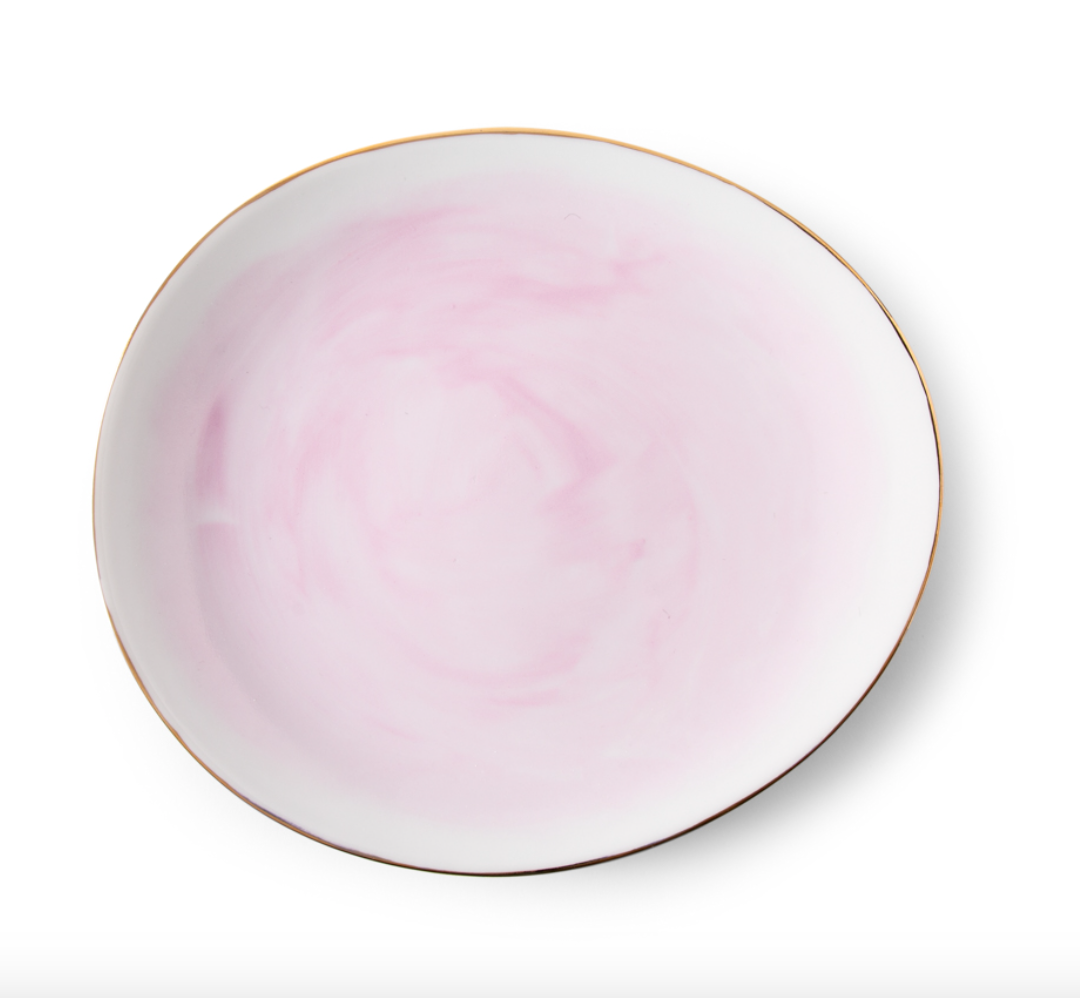The Galette Dinnerware plate by Molecot is a round hand-painted porcelain piece with a soft pink marbled pattern and a thin gold rim, shown on a white background.