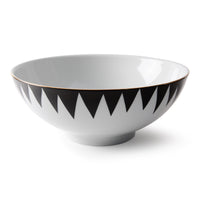 The Punk Dinnerware by Molecot is a white ceramic bowl with a black zigzag rim and thin gold edge, crafted as modern tableware and shown on a plain white background.
