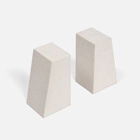 Two off-white, trapezoidal Rene Faux Shagreen Bookends by Made Goods, featuring subtle grid patterns and architectural edges, stand upright on a plain white background with light shadows cast to the left.