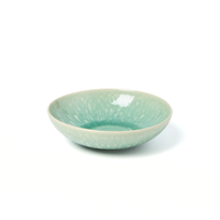 A shallow, round ceramic bowl in a soft jade green and white speckled glaze from the Jars - Rosenthal Tourron Dinnerware collection, shown on a plain white background.