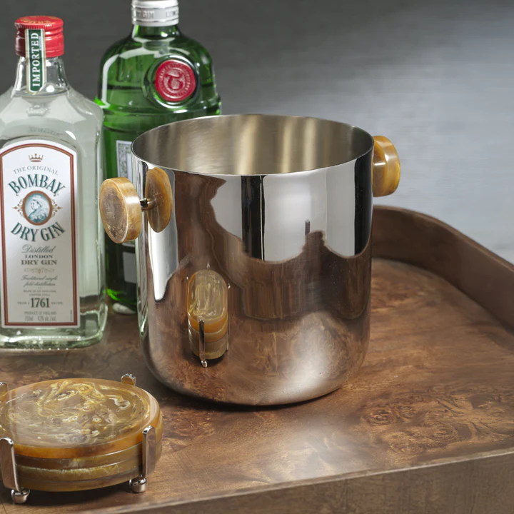 The Zodax Spector Ice Bucket in nickel and resin, paired with two bottles of gin and amber coasters on a wood tray, creates a chic setup for stylish bar entertaining.
