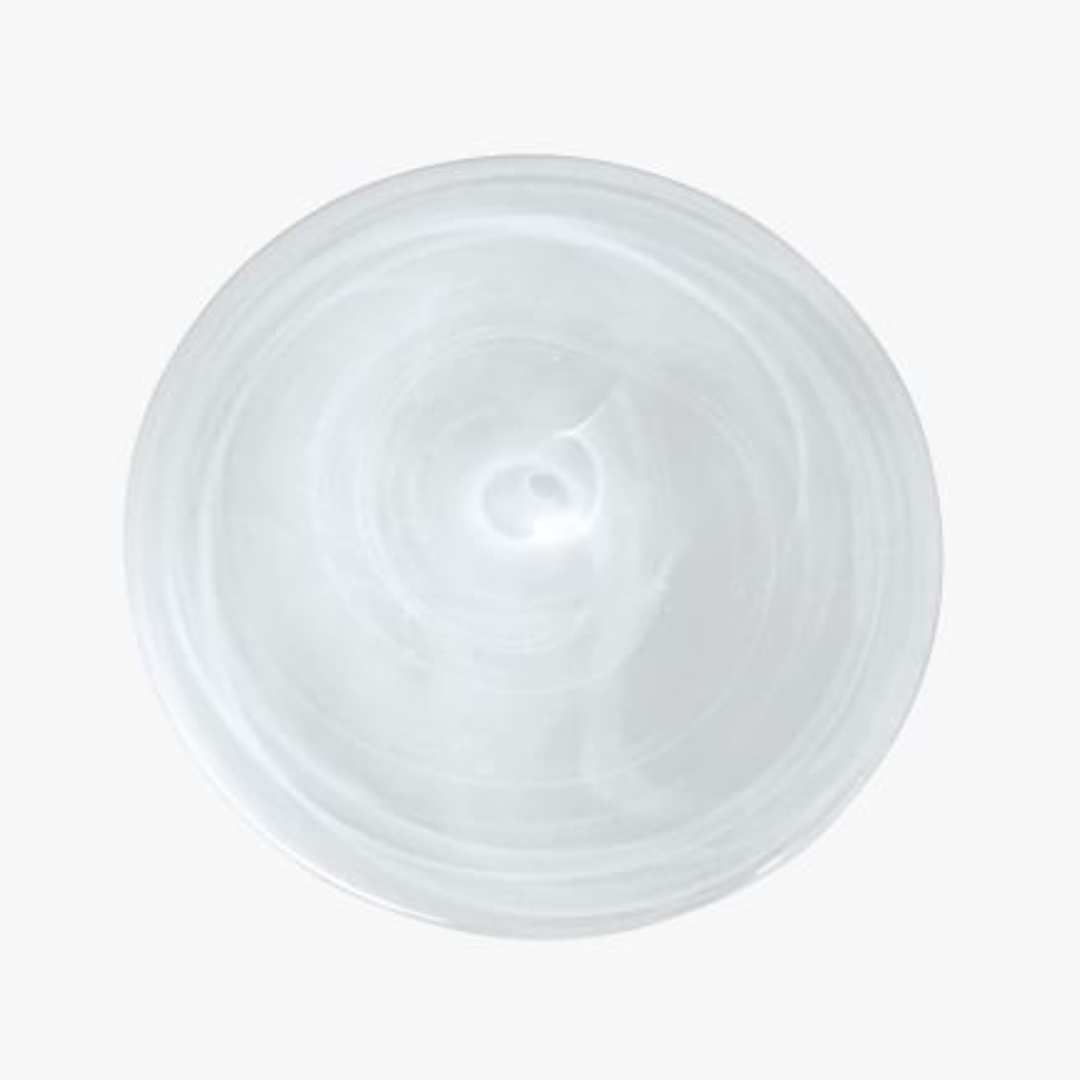A close-up, top-down view shows a clear, circular piece from the Mariposa Swirl Alabaster Dinnerware White Set of 4 against a plain white background.