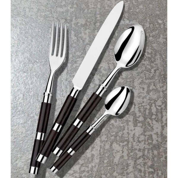 The Alain Saint-Joanis Carla Flatware Ebony 5 Piece Setting—hand-polished in France—features fork, knife, tablespoon, teaspoon, and salad fork with dark handles, arranged diagonally on a textured gray surface.