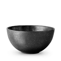 The Alchimie Dinnerware Black bowl by L'Objet features a matte black ceramic finish with a speckled texture, inspired by luxury tableware, and is photographed against a plain white background.