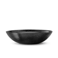 The Alchimie Dinnerware Black bowl by L’Objet sits centered on a white background, reflecting the refined elegance of luxury tableware and the timeless appeal of earthenware.