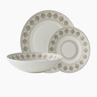 The Greg Natale Amalfi Dinnerware 3 Piece Set features a large dinner plate, salad plate, and wide bowl in white bone china, each with a matching beige and gray geometric pattern inspired by circular designs near the rim.