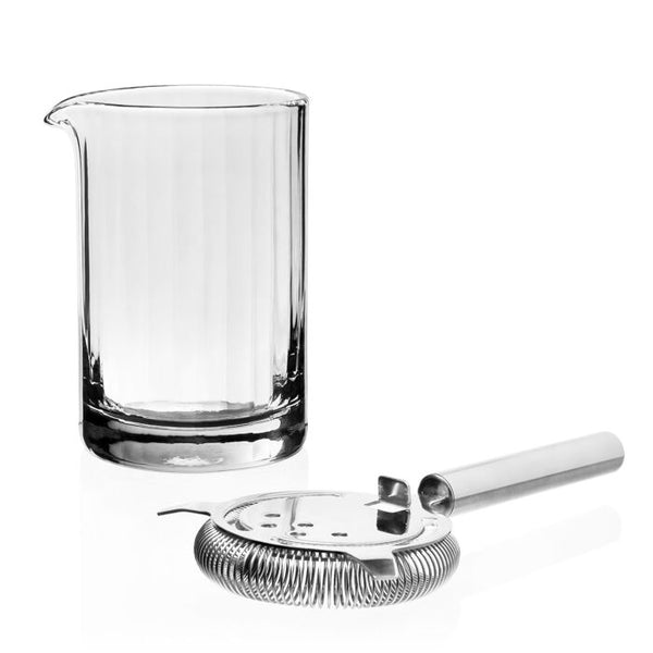 The William Yeoward Corinne Mixer & Strainer set includes a handmade crystal beaker with a pouring spout and a professional strainer, beautifully showcased against a white backdrop.