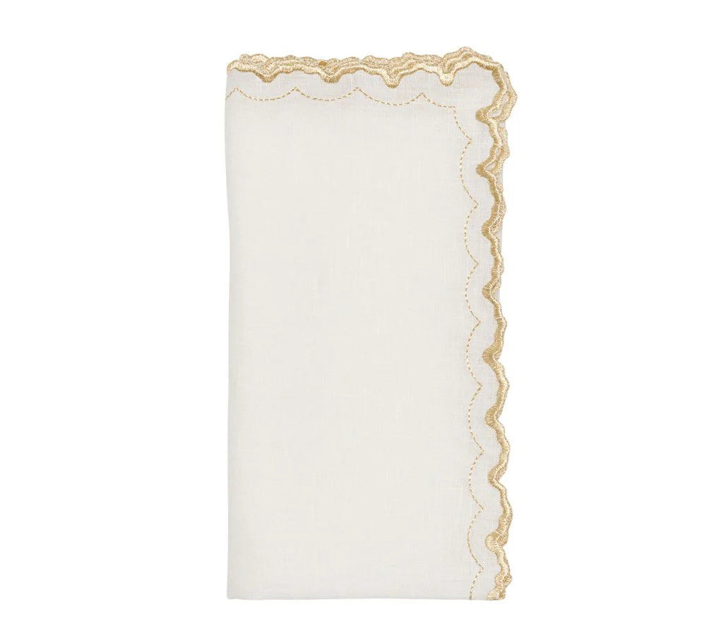 The Arches Napkin Set of 4 by Kim Seybert features folded white linen napkins with scalloped edges, a gold embroidered trim on one side, and a subtle geometric design, shown against a plain white background.