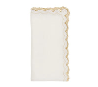The Arches Napkin Set of 4 by Kim Seybert features folded white linen napkins with scalloped edges, a gold embroidered trim on one side, and a subtle geometric design, shown against a plain white background.