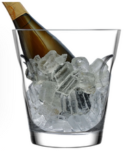 A bottle of champagne chills in the Nude Glassware Glacier Cooler, a lead-free crystal ice bucket filled with large ice cubes, set against a white background.