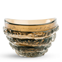 The Modena Amber Bowl by FlowDecor Inc. features a round, amber-colored design with wavy texture and thick clear ribbed layers around the exterior, offering a sculptural, handcrafted look perfect for decorative displays.