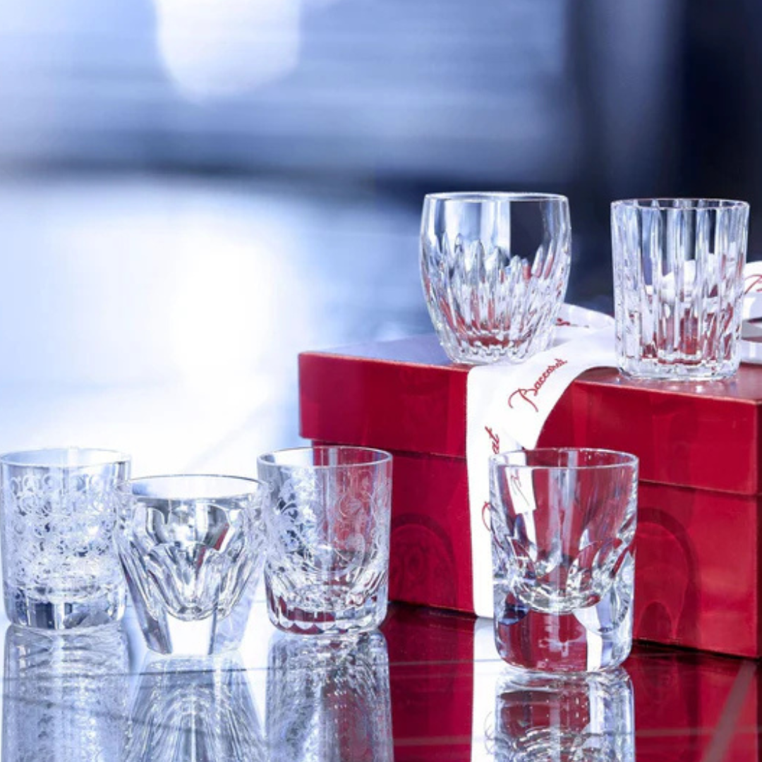 The Baccarat Take A Shot - Les Mini Set includes six elegant mini shot glasses, beautifully displayed on a red gift box with a white ribbon—perfect glassware for gifting.