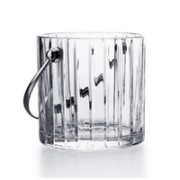 The Baccarat Harmonie Ice Bucket features vertical ridges and a metal handle, crafted from clear crystal—luxury barware inspired by timeless elegance.