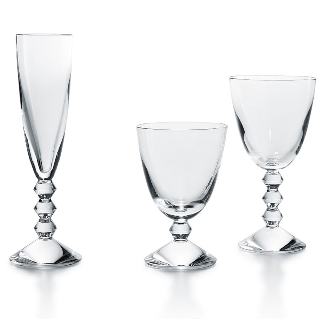 Three Baccarat Vega Water Glass goblets, each featuring a distinctive geometric stacked-sphere stem, are arranged side by side against a white background. The luxury set includes a flute, wine glass, and goblet.
