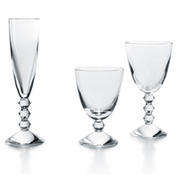 Three Baccarat Vega Water Glass goblets, each featuring a distinctive geometric stacked-sphere stem, are arranged side by side against a white background. The luxury set includes a flute, wine glass, and goblet.