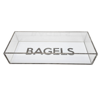 The Eye Candy Bagel Tray is a rectangular, clear silver marble acrylic box with "BAGELS" in bold capitals on the inside bottom. Food safe and lidless, it offers a modern touch for serving bagels.