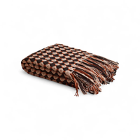 The Hampton Cotton Throw by Meso Goods features a handloom flatweave with alternating brown and tan geometric circles, wool fringe, and is made from cotton.