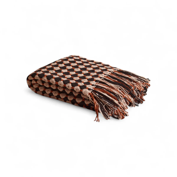 The Hampton Cotton Throw by Meso Goods features a handloom flatweave with alternating brown and tan geometric circles, wool fringe, and is made from cotton.