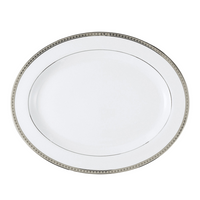 The Bernardaud Athena Platinum Dinnerware features a white oval plate with a silver and black decorative border, shown against a plain white background.
