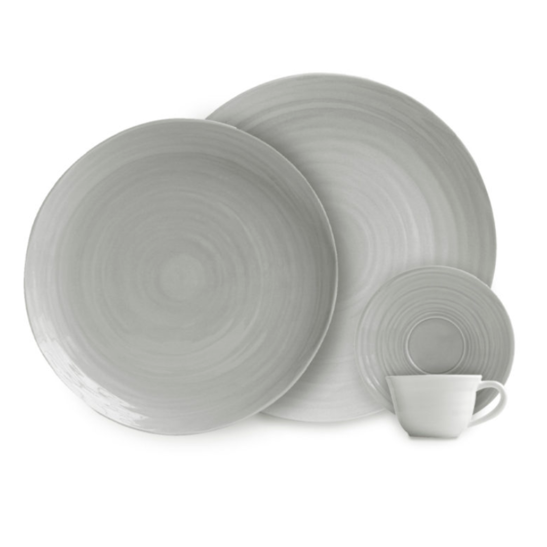 A set of four grey Bernardaud Origine Dinnerware pieces, including two dinner plates, one small plate, and a matching cup—all crafted from Limoges porcelain with a subtle circular textured pattern.