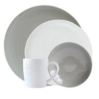 The Origine Dinnerware Grey set by Bernardaud features a large gray plate, small white plate, gray bowl, and white mug—crafted from fine Limoges porcelain and stacked together against a white background.