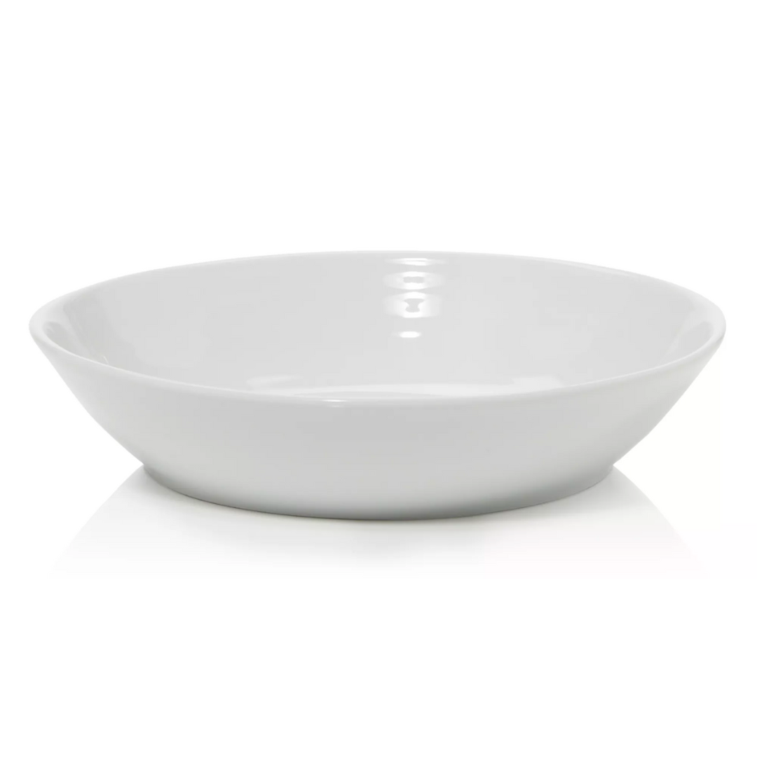 The Bernardaud Origine Dinnerware White features a plain, white, round ceramic bowl with a wide rim, elegantly photographed on a white background.