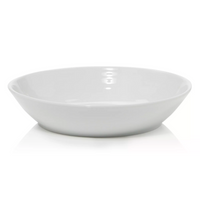 The Bernardaud Origine Dinnerware White features a plain, white, round ceramic bowl with a wide rim, elegantly photographed on a white background.
