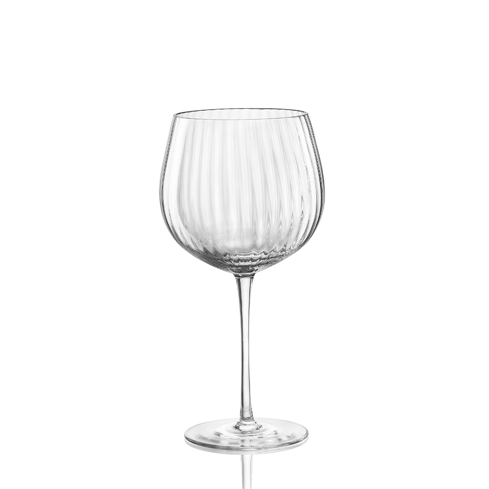 The Nason Moretti Tolomeo Red Wine Glass features clear blown glass with a wide, round bowl and vertical ribbed texture on a long, thin stem and flat base. Made in Italy. Hand wash recommended. Pictured against a white background.