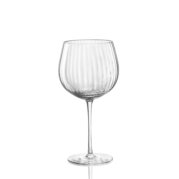 The Nason Moretti Tolomeo Red Wine Glass features clear blown glass with a wide, round bowl and vertical ribbed texture on a long, thin stem and flat base. Made in Italy. Hand wash recommended. Pictured against a white background.